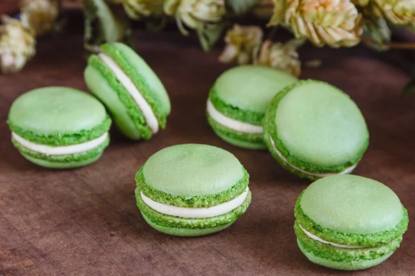 Macaroons verdes em fundo de madeira escura — Fotografia de Stock