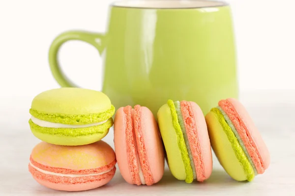 Green and pink colorful macaroons with green mug — Stock Photo, Image