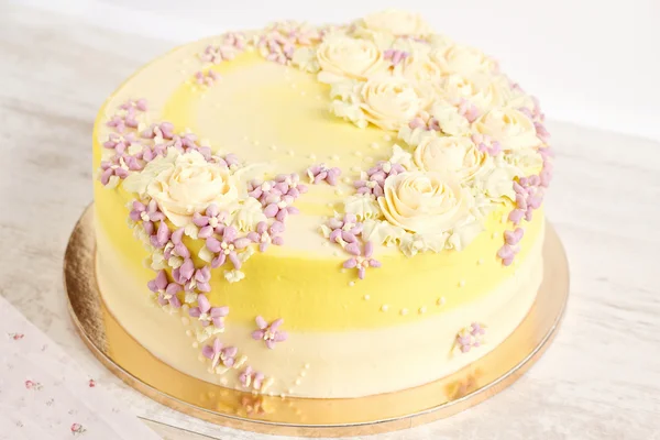 Bolo amarelo com flores de creme — Fotografia de Stock