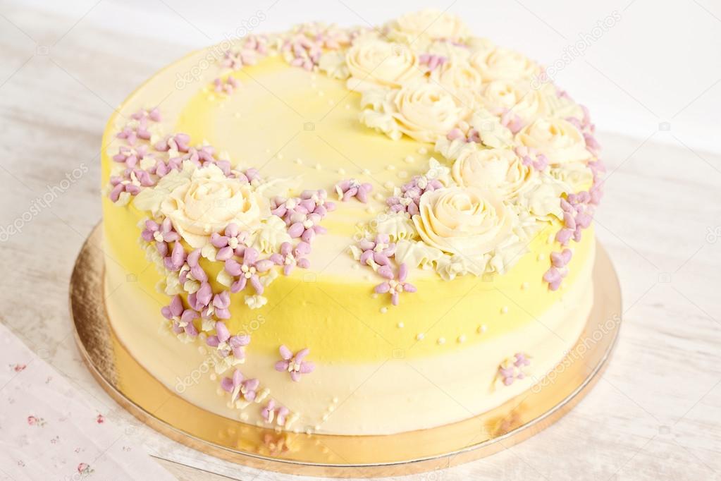 Yellow cake with cream flowers