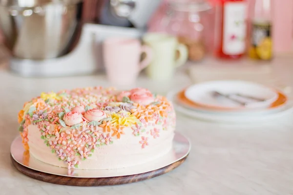 เค้กสีชมพูพาสเทลตกแต่งด้วยครีม ดอกไม้บนครัว — ภาพถ่ายสต็อก