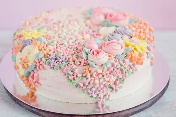 Pastell rosa Kuchen mit cremefarbenen Blumen dekoriert — Stockfoto