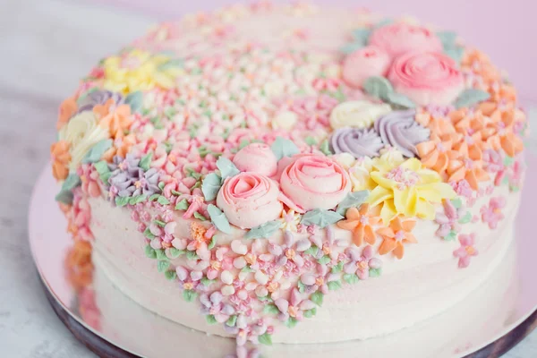 Pastell rosa Kuchen mit cremefarbenen Blumen dekoriert — Stockfoto