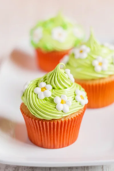 Pasen cupcakes versierd met bloemen op wit bord — Stockfoto