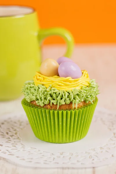 Magdalenas de Pascua decoradas con huevos en el nido. Fondo naranja w — Foto de Stock