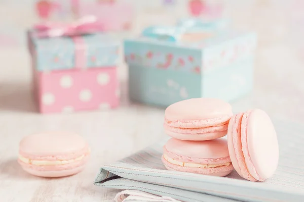 Rosa Makronen mit Geschenkschachteln auf Hintergrund — Stockfoto