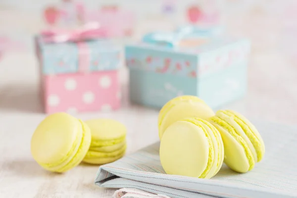 Macarrones amarillos con cajas de regalo sobre fondo — Foto de Stock