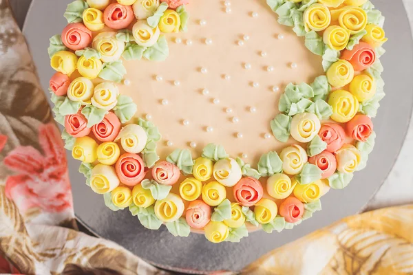 Gräddbakelse dekorerad med små gula och rosa rosor — Stockfoto