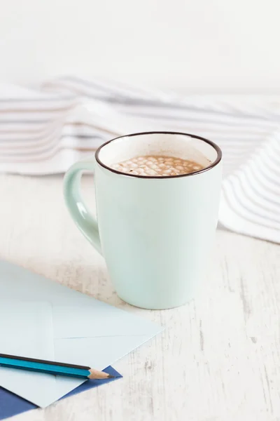 Cacau com marshmallow em copo azul claro no fundo branco — Fotografia de Stock