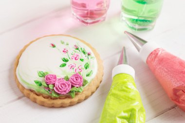 Painted gingerbread cookie with roses. Top view clipart