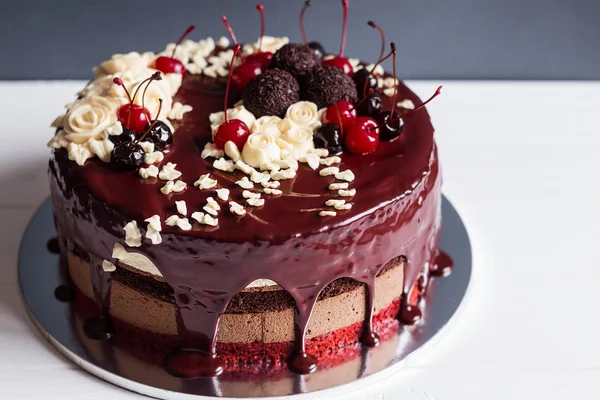 Schichtkuchen dekoriert mit Schokoglasur, Sahneblüten und Che — Stockfoto