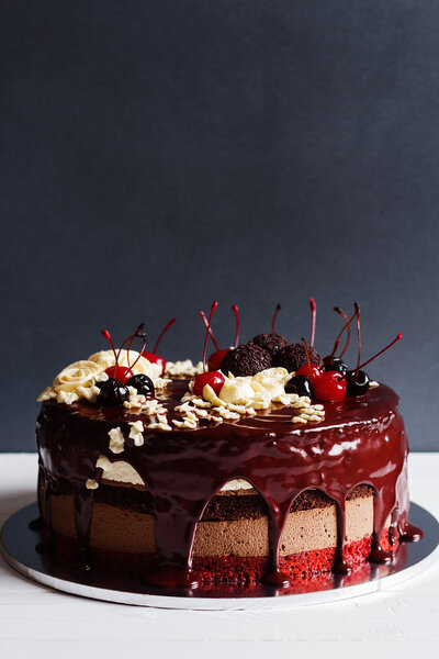 Слой торт украшен шоколадной глазурью, кремовые цветы и che
