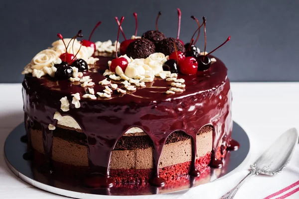 Layer cake decorated with chocolate glaze, cream flowers and che — Stock Photo, Image