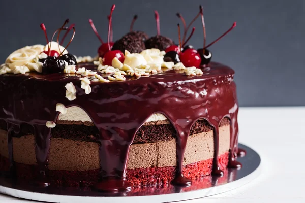 Layer cake decorated with chocolate glaze, cream flowers and che — Stock Photo, Image