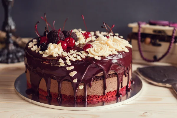 Layer cake decorated with chocolate glaze, cream flowers and che — Stock Photo, Image