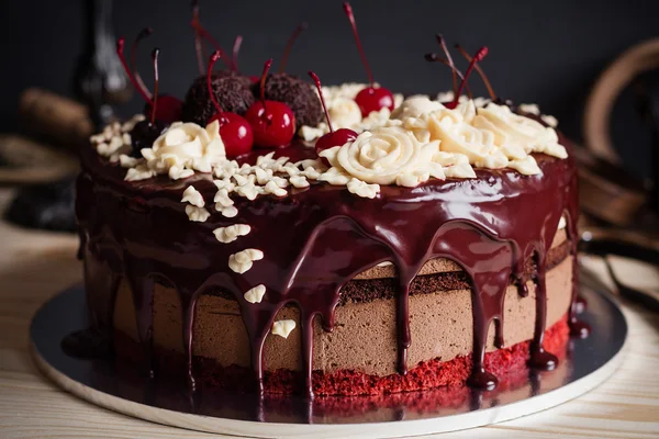 Layer cake decorated with chocolate glaze, cream flowers and che — Stock Photo, Image