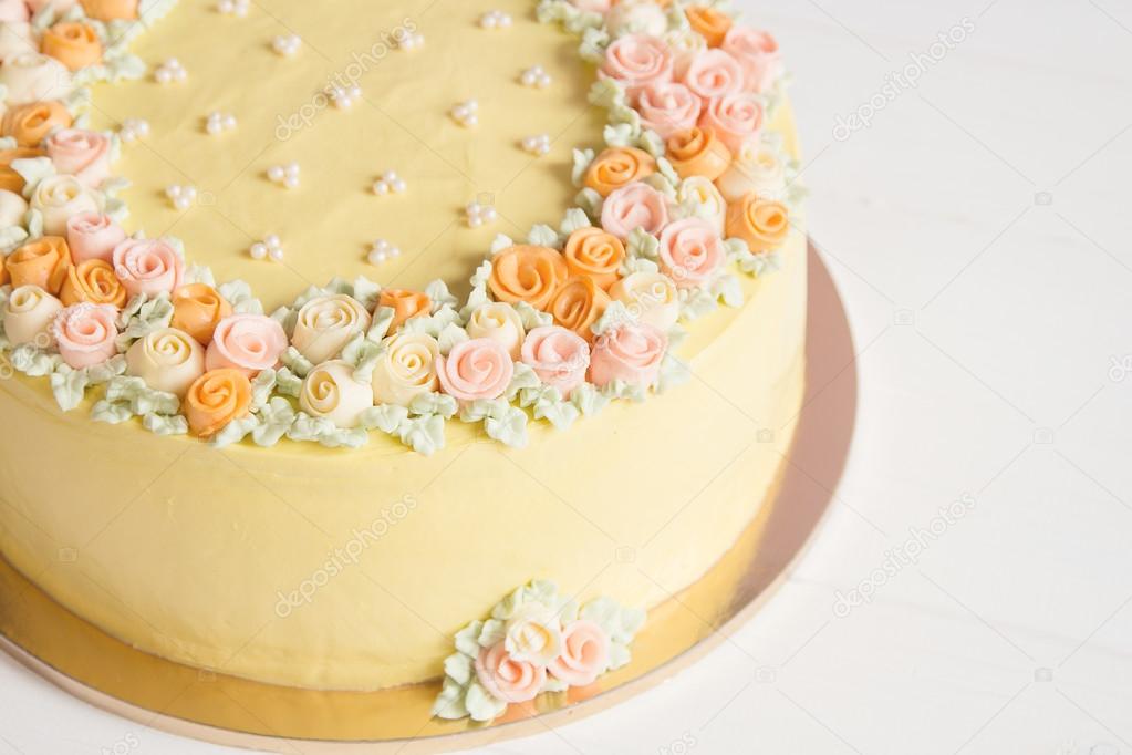 Pale yellow mousse cake with pastel cream flowers