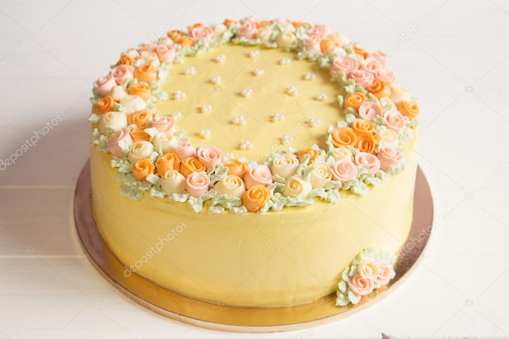 Pale yellow mousse cake with pastel cream flowers