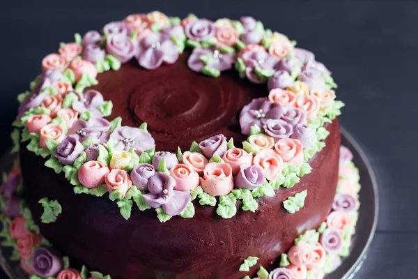 Hausgemachte Schokoladenkuchen mit bunten cremefarbenen Blüten — Stockfoto