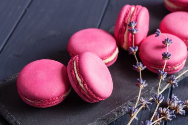 Siyah arka plan üzerine pembe ahududu macaroons