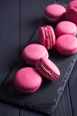 Siyah arka plan üzerine pembe ahududu macaroons