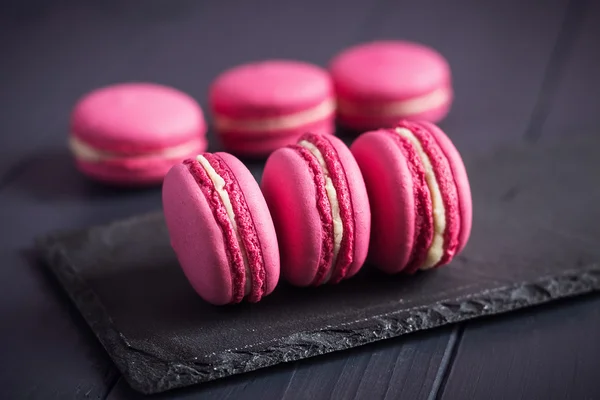 Macaroons de framboesa rosa no fundo preto — Fotografia de Stock