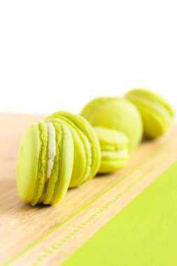 Ahşap masa üzerinde çapraz olarak düzenlenmiş yeşil macaroons