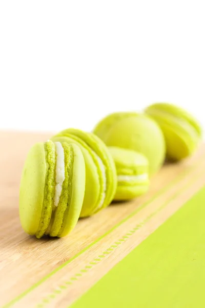 Green macaroons arranged diagonally on wooden table — Stock Photo, Image