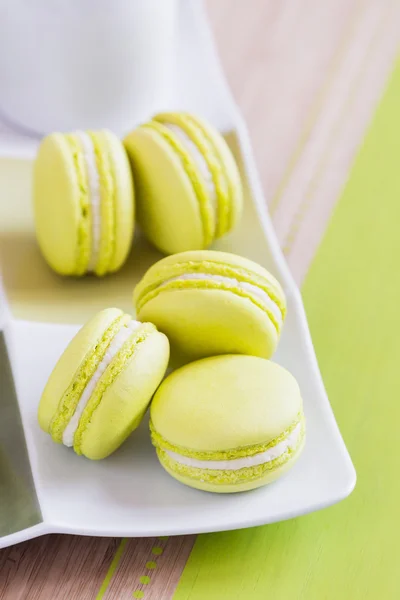Green macaroons on a square plate. Top view — Stock Photo, Image