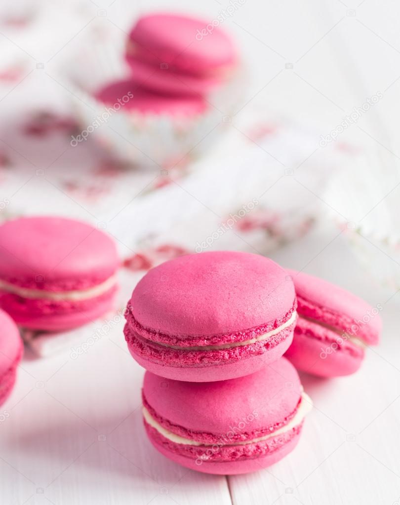 ink raspberry macaroons on white wooden background