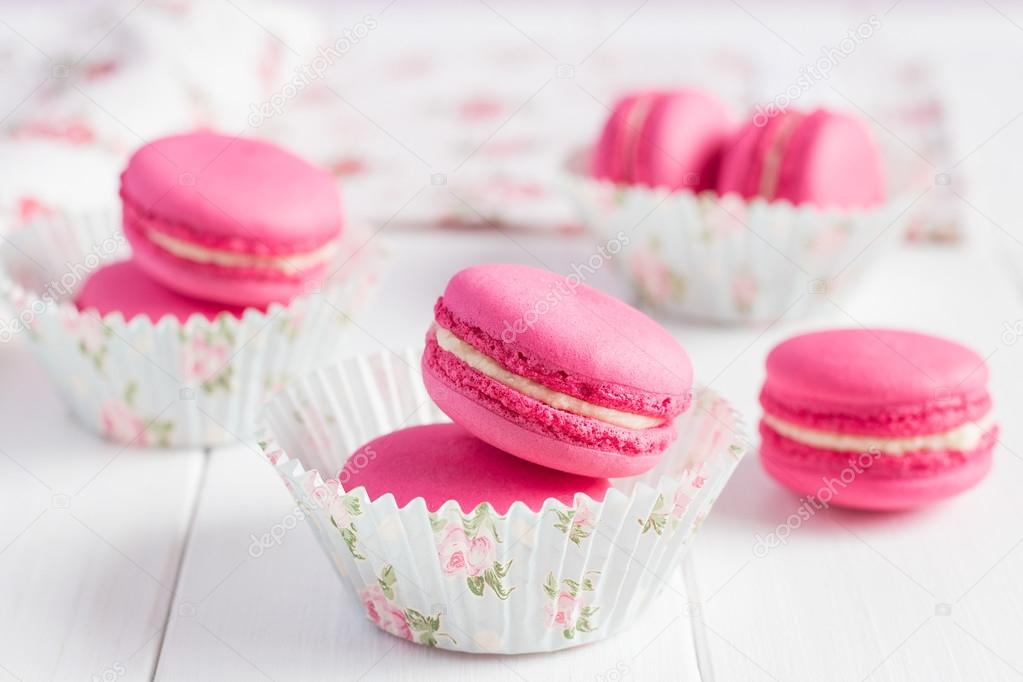 ink raspberry macaroons on white wooden background
