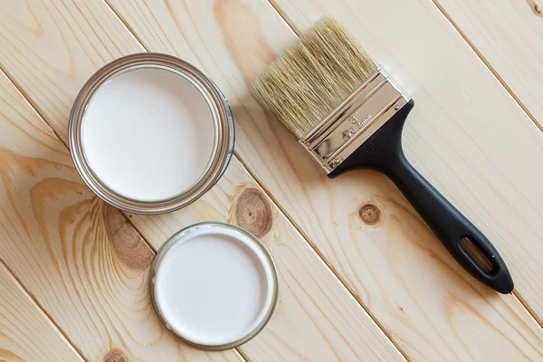 Blikken van verf en penseel op houten achtergrond — Stockfoto