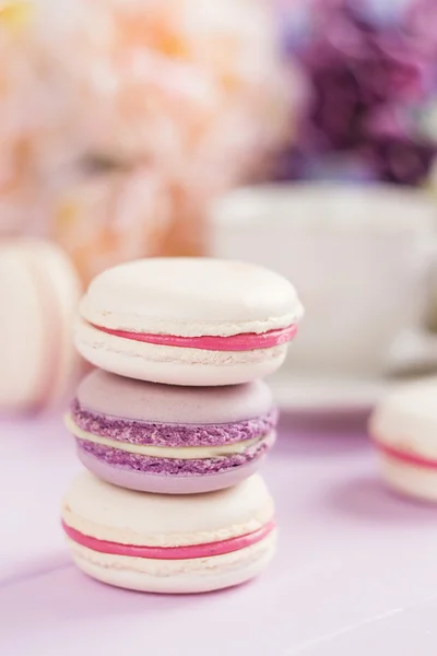 Pastel colored macaroons with floral background — Stock Photo, Image