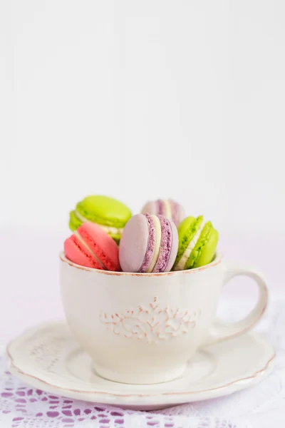 Coloridos macarrones pequeños en taza de café vintage — Foto de Stock