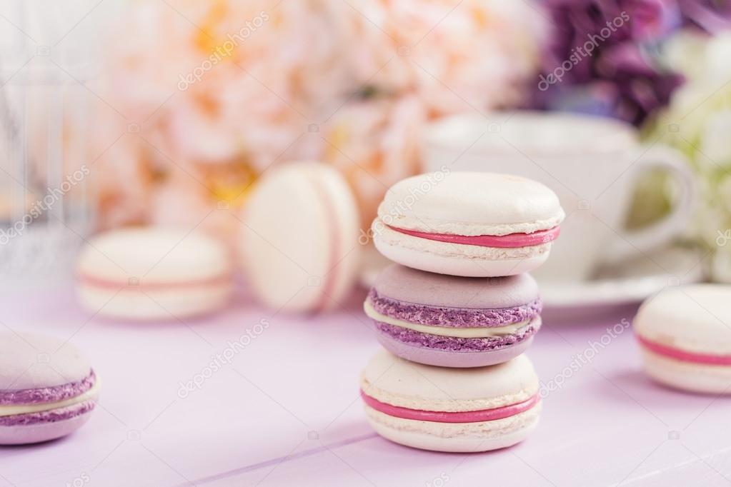 Pastel colored macaroons with floral background