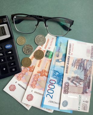 Yeşil zemin üzerinde para, madeni para, nokta ve hesap makinesi