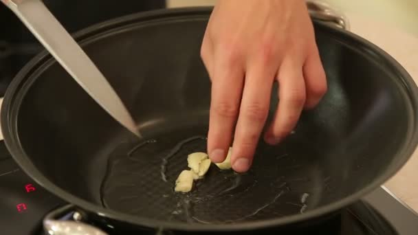 Wok s horkým olejem a prolisovaný česnek — Stock video