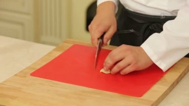 Bir bıçak ile kesme tahtası üzerinde sarımsak kıyma Şef