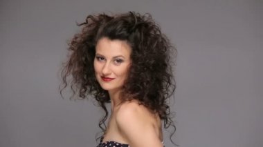 Genç esmer, uzun kahverengi kıvırcık saçlı dans eden