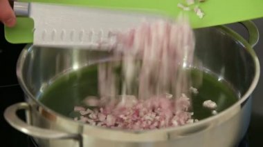 Şef doğranmış soğan tava içine düşer.