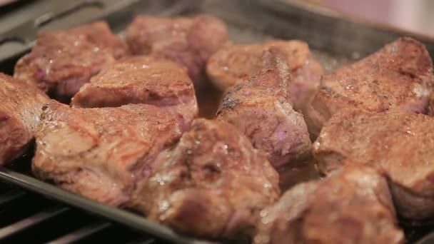 Rokerige gebakken steakes in een pan — Stockvideo