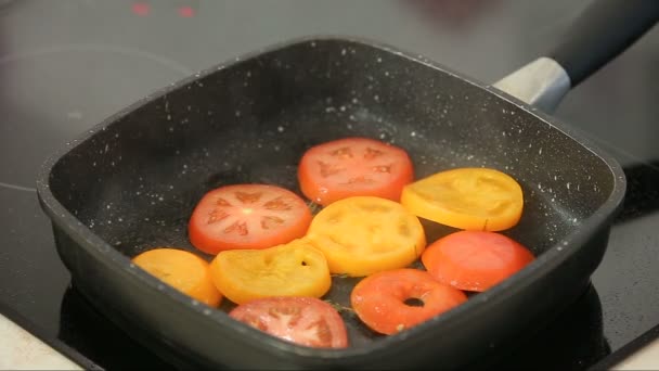 검은 팬에서 굽는 신선한 tomatoe 조각 — 비디오