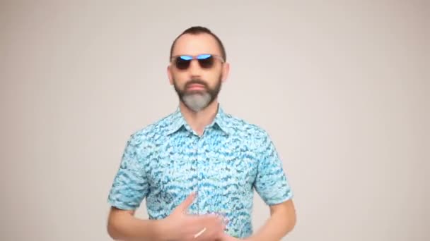Взрослый бородатый мужчина в солнцезащитных очках позирует и танцует — стоковое видео