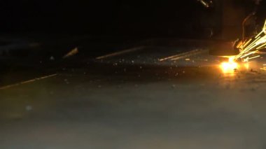 Parlak kıvılcımlarla metal kesen lazer.