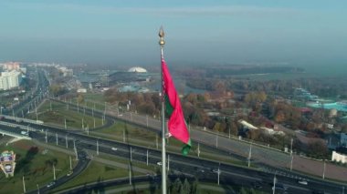 Beyaz Rusya bayrağı mavi gökyüzü ve güneşli bir sabahta Minsk şehri üzerinde dalgalanıyor.