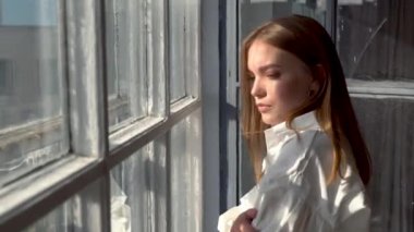 Pencerenin yanında poz veren rahat bir model.