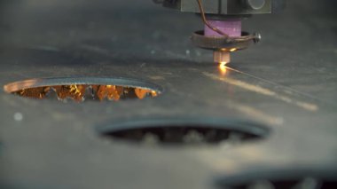 Parlak kıvılcımlarla metal kesen lazer.