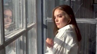 Pencerenin yanında poz veren rahat bir model.