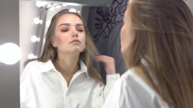 Sandalyede oturan bir fotoğrafa poz veren rahat bir model.