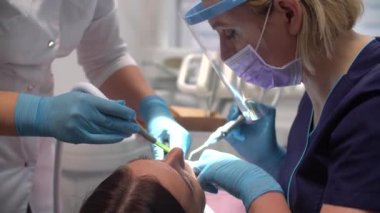 Kadın dişçi asistanıyla çalışıyor.